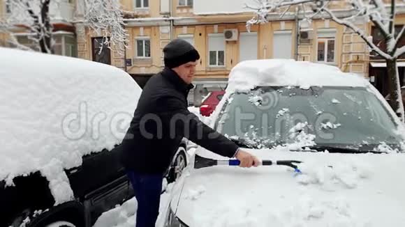 4K录像显示年轻人早上在上班前把车上的雪视频的预览图