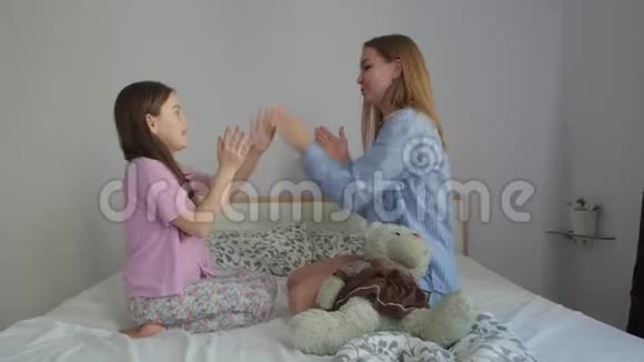 妈妈和女儿在玩他们的手视频的预览图