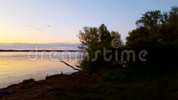 夏日清晨平静的湖水美景黎明时宁静的湖畔风光色彩斑斓的红色橙色视频的预览图