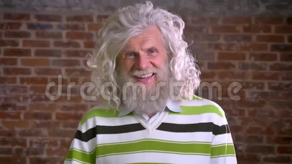 白种人留着长长的白胡子和大波浪头的老白种人正高兴地笑着高兴地指着砖头视频的预览图