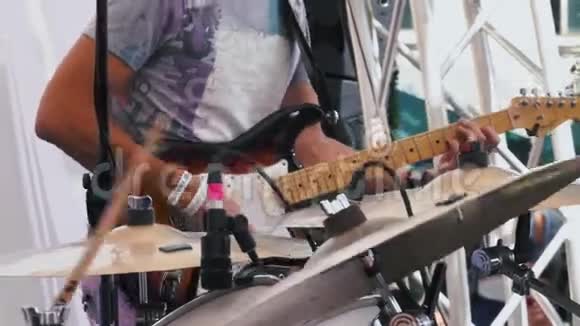 吉他手在摇滚乐队中演奏电吉他在现场表演中聚焦到背景视频的预览图