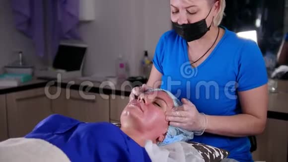 美容诊所年轻的女人得到一个放松的面部按摩按摩前额视频的预览图