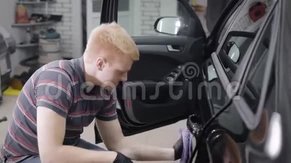 一名男性工人用干毛巾仔细打磨汽车挡泥板视频的预览图