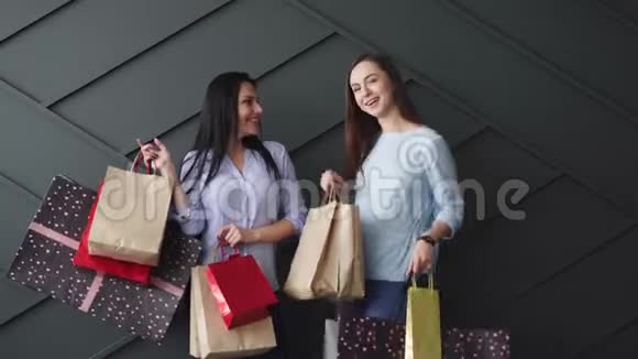 两个快乐的女朋友手里拿着购物袋黑色星期五概念视频的预览图