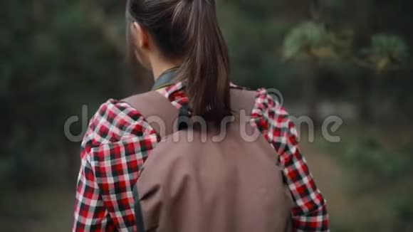 旅游女摄影师在森林中徒步旅行后视图视频的预览图