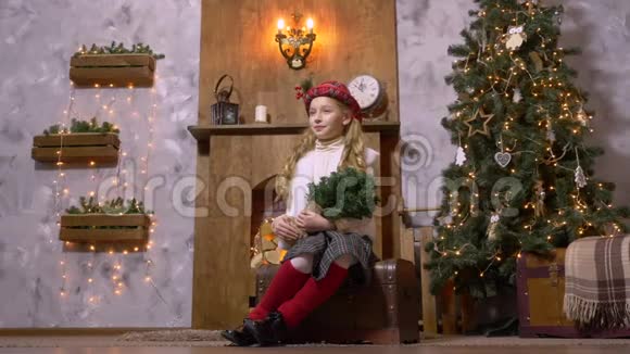 摄影棚里一个在圣诞树旁摆着冷杉树枝的少女视频的预览图