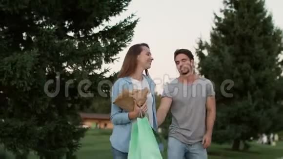 快乐的一对相爱的夫妇在夏天的公园里散步浪漫情侣户外视频的预览图