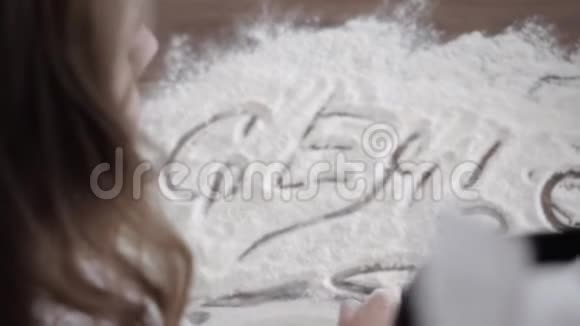 男人和女人用面粉在桌子上画字母视频的预览图