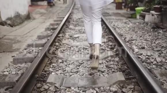 美丽优雅的时尚女孩走在街上的铁路关口特写跟在腿上旅程视频的预览图