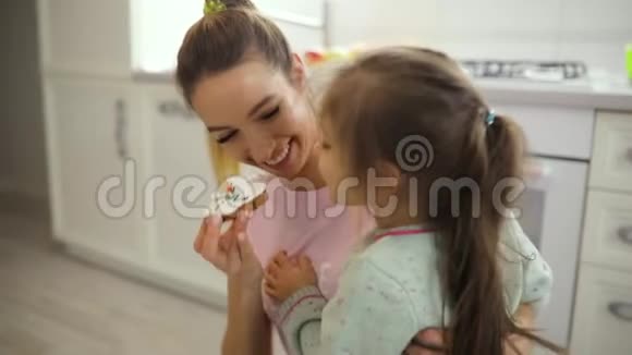 快乐的妈妈在厨房里玩饼干逗女儿玩视频的预览图
