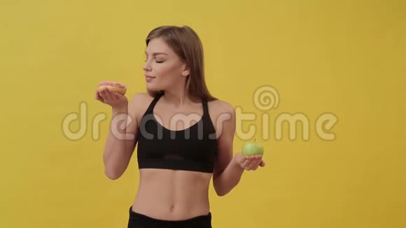 节食的运动女孩在甜甜圈和苹果之间选择健康生活方式视频的预览图