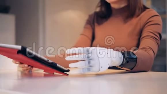 年轻女子用机械手臂从杯子里喝东西视频的预览图