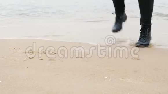 旅行概念女人穿着皮鞋在海边的沙滩上跳舞在海浪中驻足视频的预览图