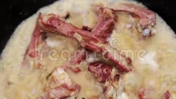 街头美食炖排骨放在酱油里洋葱在火炭火和大锅里煮视频的预览图