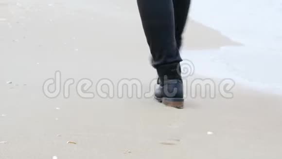 旅行概念的女人穿着黑色皮鞋踏着沙滩踏着大海走出地平线视频的预览图