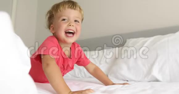 有趣的孩子在床上嬉笑视频的预览图