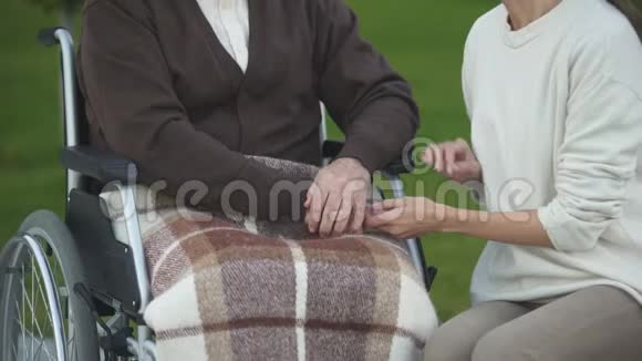女性握着老年男性的手轻轻抚摸着老年男性的手在医院看望爷爷视频的预览图