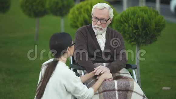 坐在轮椅上的老人和年轻的退伍老太太在和孙女聊天视频的预览图
