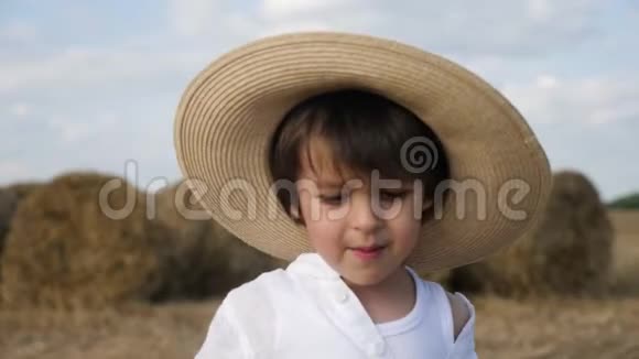 穿着白衬衫戴草帽的男孩光着脚在斜坡上视频的预览图