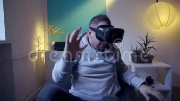 懒散的男人在家里脱下害怕虚拟现实视频的预览图