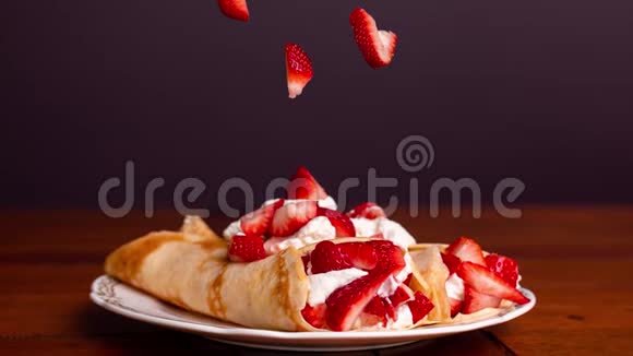美味的薄饼里面装满了草莓和奶油草莓落在薄饼上视频的预览图