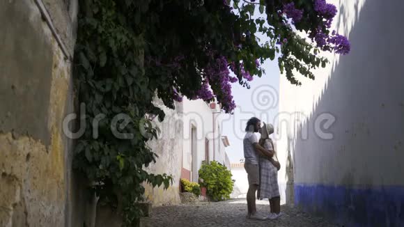 一对夫妇在灌木丛附近的老建筑之间接吻视频的预览图