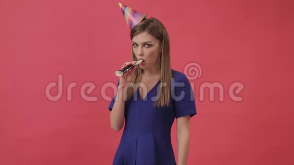 悲伤的女孩戴着节日的帽子吹着派对的哨子紫色背景工作室视频的预览图