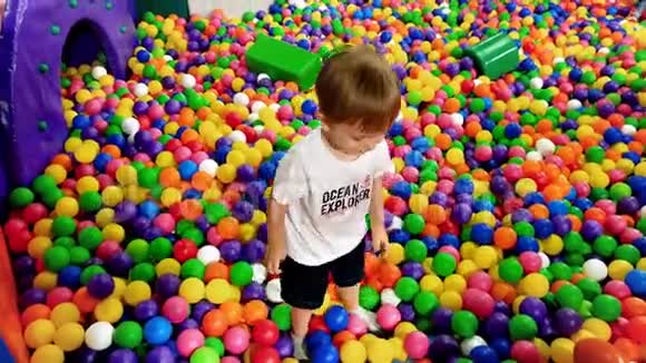4k小男孩在游乐场玩游戏的视频里面装满了五颜六色的塑料球视频的预览图
