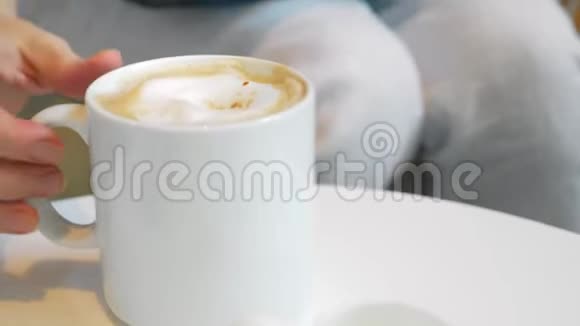 一个年轻的女人喝咖啡用笔记本电脑特写视频的预览图