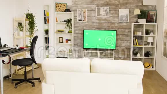 明亮明亮的客厅里有绿色屏幕电视视频的预览图