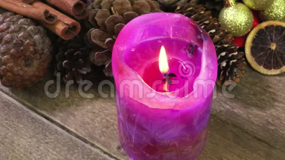 在圣诞装饰中点燃紫色的圣诞蜡烛视频的预览图