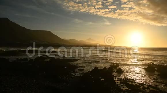 飞越海浪面对美丽的日落和地平线上的山脉视频的预览图