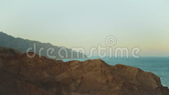 埃及西奈山脉的日落令人惊叹地平线上有蓝色的大海山峰慢动作4K视频的预览图