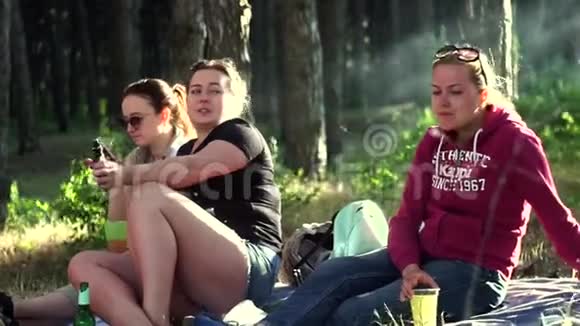 三个漂亮的年轻女孩坐在床上穿着牛仔裤运动衫短裤服装运动鞋视频的预览图