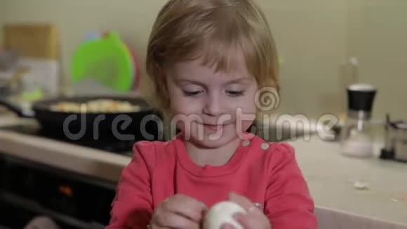 一个小女孩用一个煮熟的鸡蛋清理外壳视频的预览图