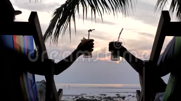在日落时分一对夫妇正在享用鸡尾酒酒杯视频的预览图