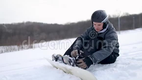 男子锁定滑雪板上的靴子视频的预览图