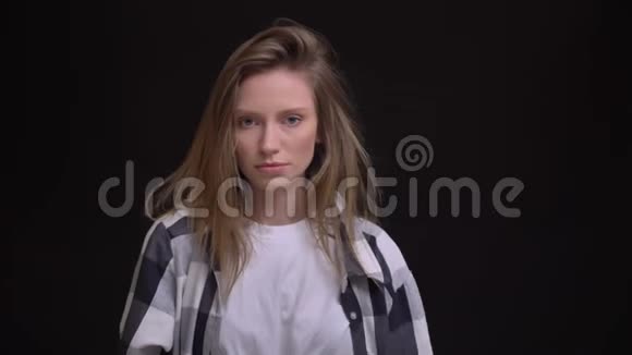 年轻的白种人长发女孩的肖像穿着格子衬衫时尚地摆成黑色背景的相机视频的预览图