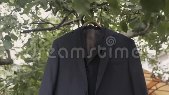 新娘夹克挂在一棵树上的花园里视频的预览图