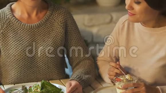 女人吃沙拉她的朋友吃甜食医疗保健和垃圾食品视频的预览图