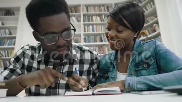 非洲学生在图书馆的笔记本上做笔记视频的预览图