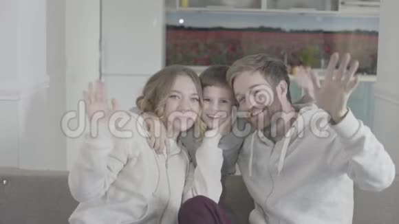 一家人幸福快乐父母手挽手坐在沙发上视频的预览图
