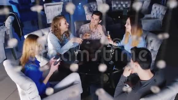 年轻人在咖啡馆里放松享受智能手机喝着酒杯中的香槟视频的预览图