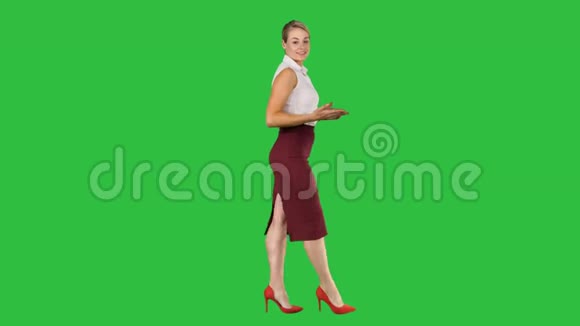 一位女商人非常积极地向前走在绿色屏幕上和摄像机交谈用彩色键视频的预览图