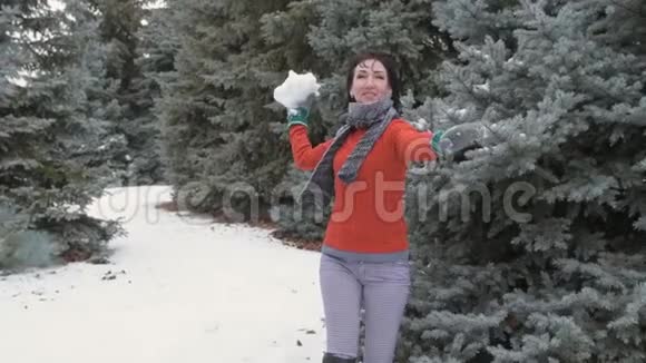 女人在冬天的森林里扔雪球美丽的风景和雪杉树视频的预览图