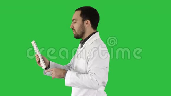 年轻医生视频聊天平板上的绿色屏幕铬键视频的预览图
