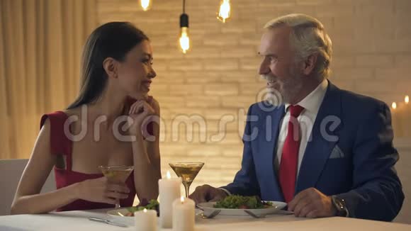 服务员把比尔带给老百万富翁和年轻的女士共进晚餐情人视频的预览图