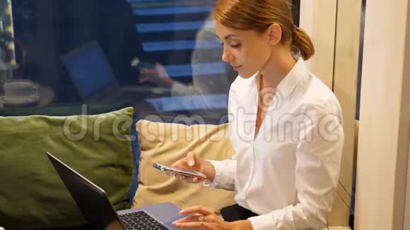 商务女性在智能手机上发短信在笔记本上工作视频的预览图