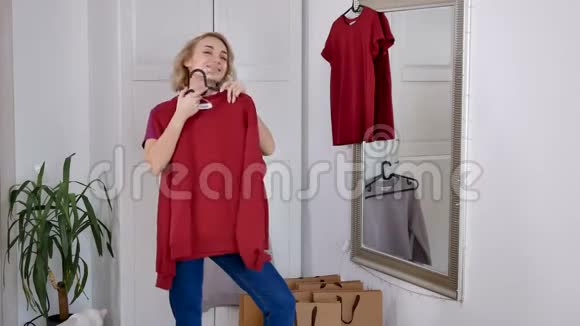 快乐的女人在家买东西后试着穿新衣服视频的预览图