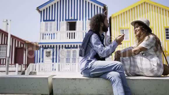 男人在五颜六色的建筑附近喂女朋友视频的预览图